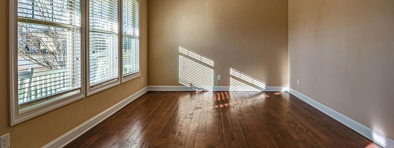 Spacious minimalist workout room with large windows and sunlight